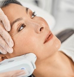 Competent salon worker doing ultra sound therapy and using sterile gloves during procedure