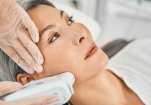 Competent salon worker doing ultra sound therapy and using sterile gloves during procedure